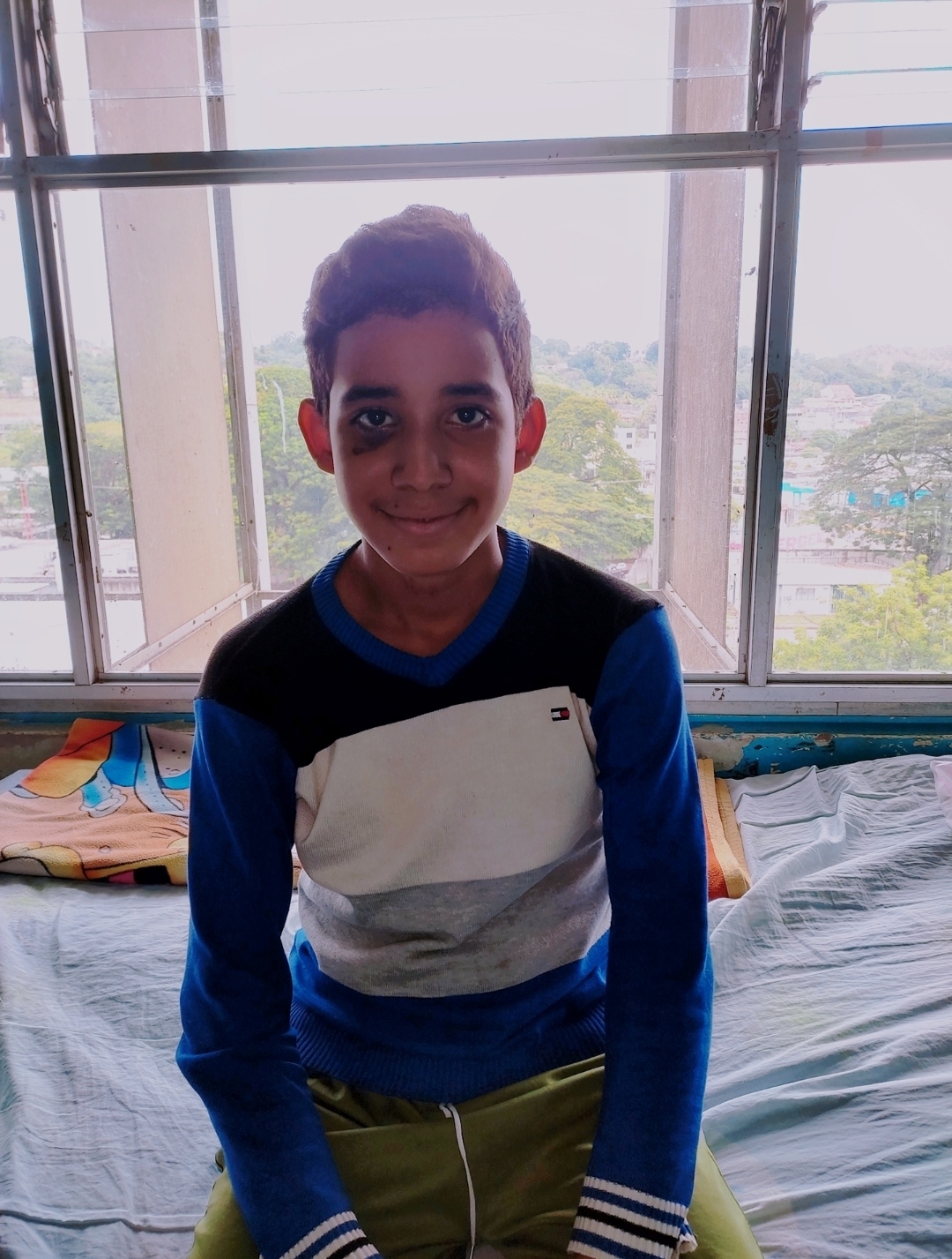 A boy recovering by a sunlit hospital window